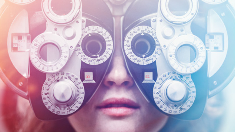 Woman looking through a phoropter, the optometry tool