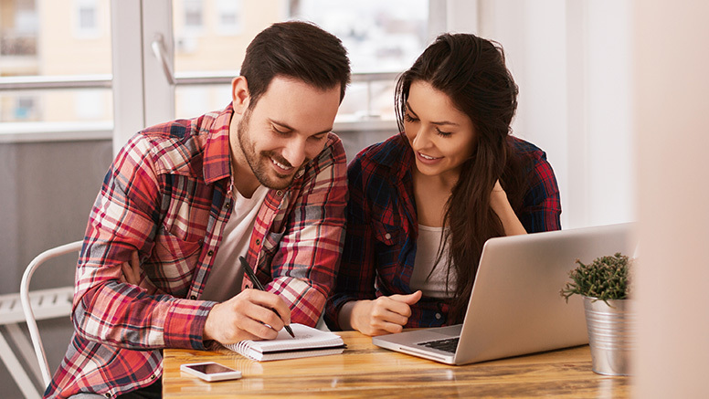 Couple planning their staycation in a notebook