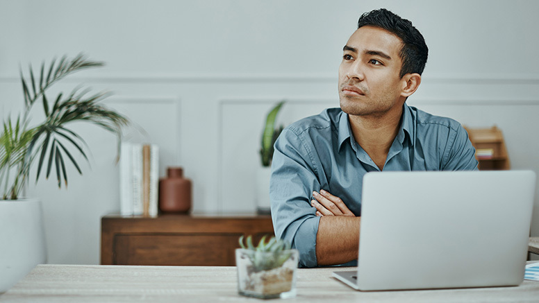 Man sits contemplating at his workspace