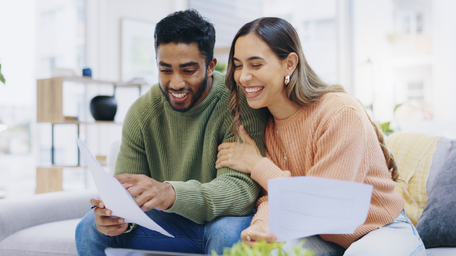 Couple smiling together and looking at documents