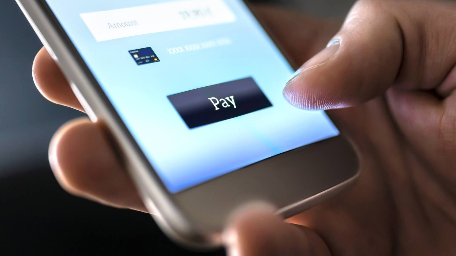 Photo of a person making a payment on a phone