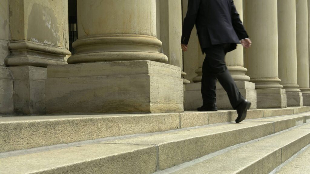 Image of a man walking into a courthouse