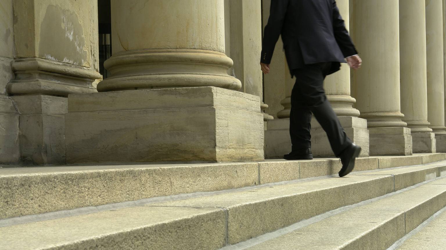 Image of a man walking into a courthouse