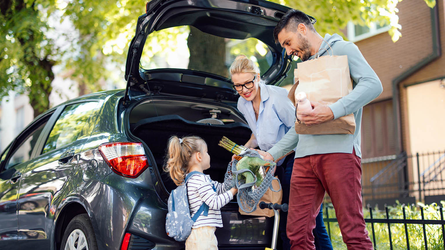 American family unloads groceries from SUV