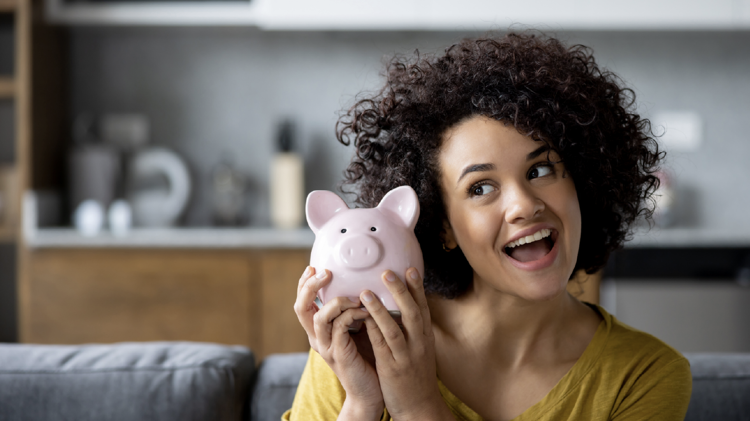Woman smiling holding piggybank demonstrating savings challenges