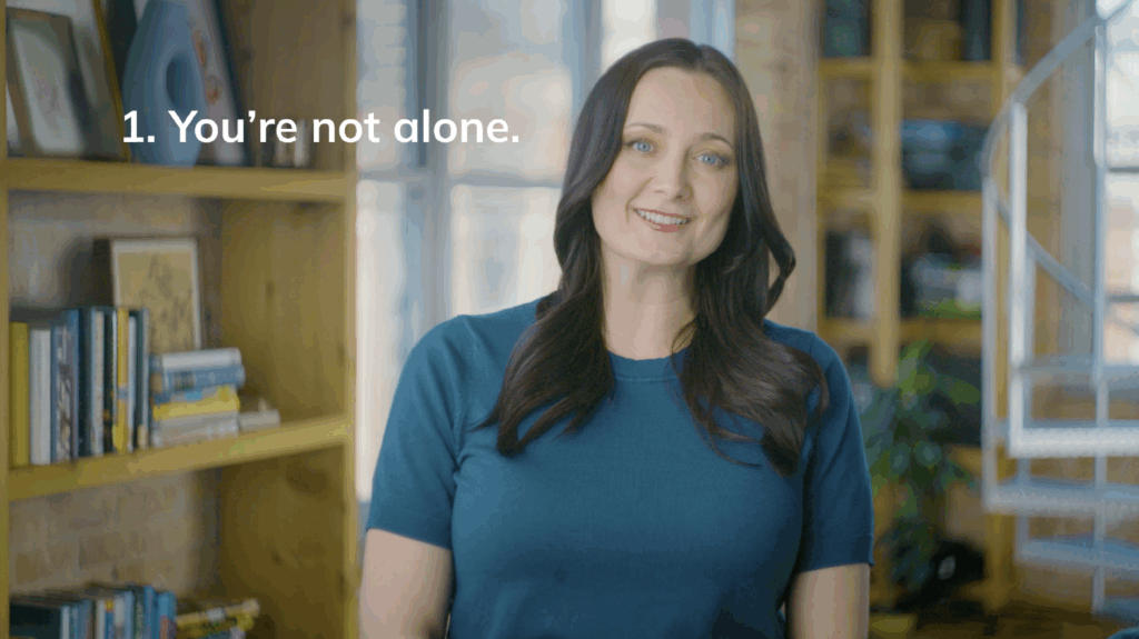 Dr. Erika Rasure smiles next to the tip "You're not alone" in Navigating Shame About Debt video