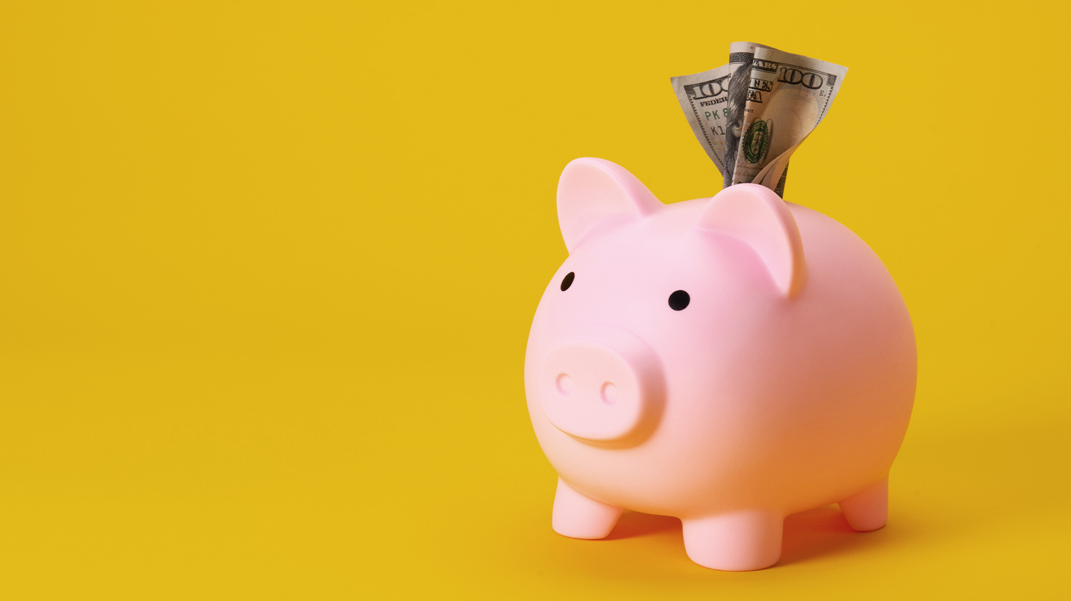 A piggy bank with money sticking out of the coin slit