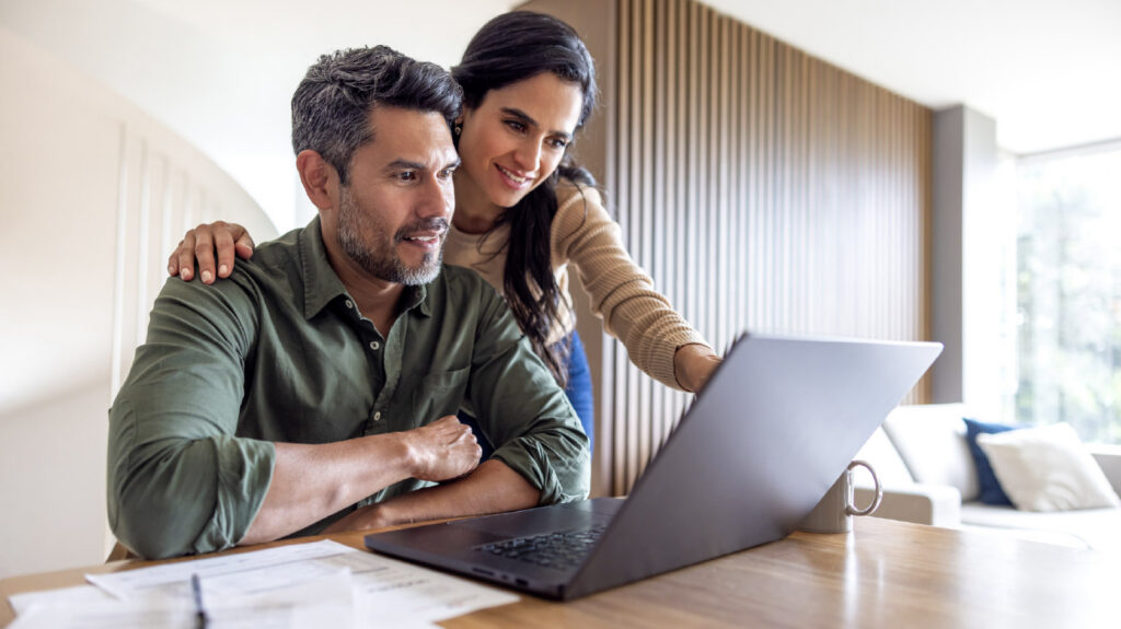 a couple looking at a laptop discussing their finances