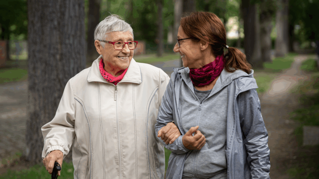 A middle aged woman walks with an older woman