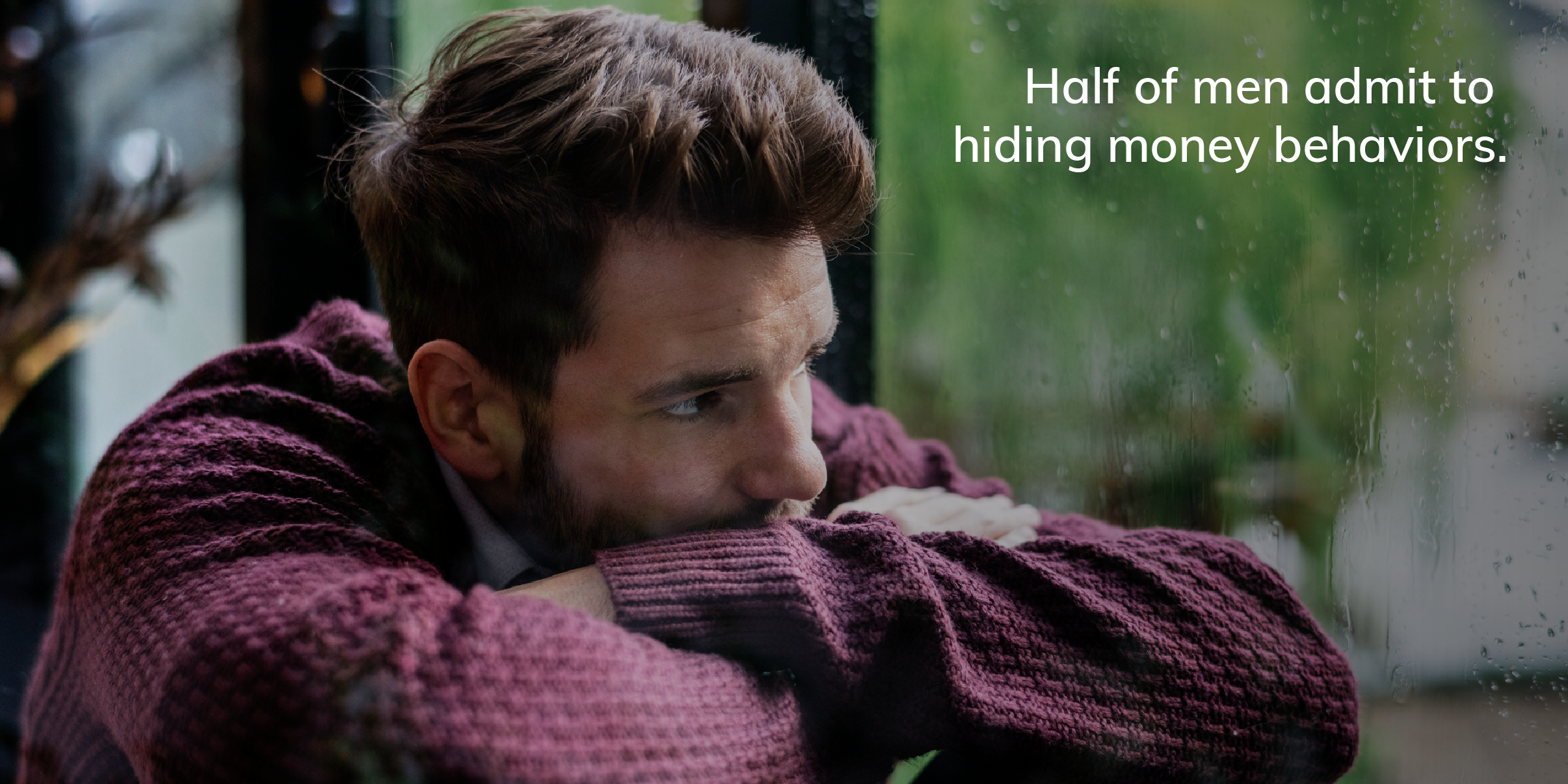 Man in his 30s slumps in front of a window on a rainy day, looking wistful, with the text: "Half of men admit to hiding money behaviors."